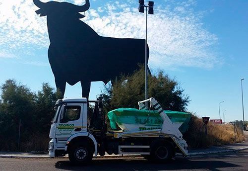 Un camión de volteo está estacionado frente a una estatua de un toro.