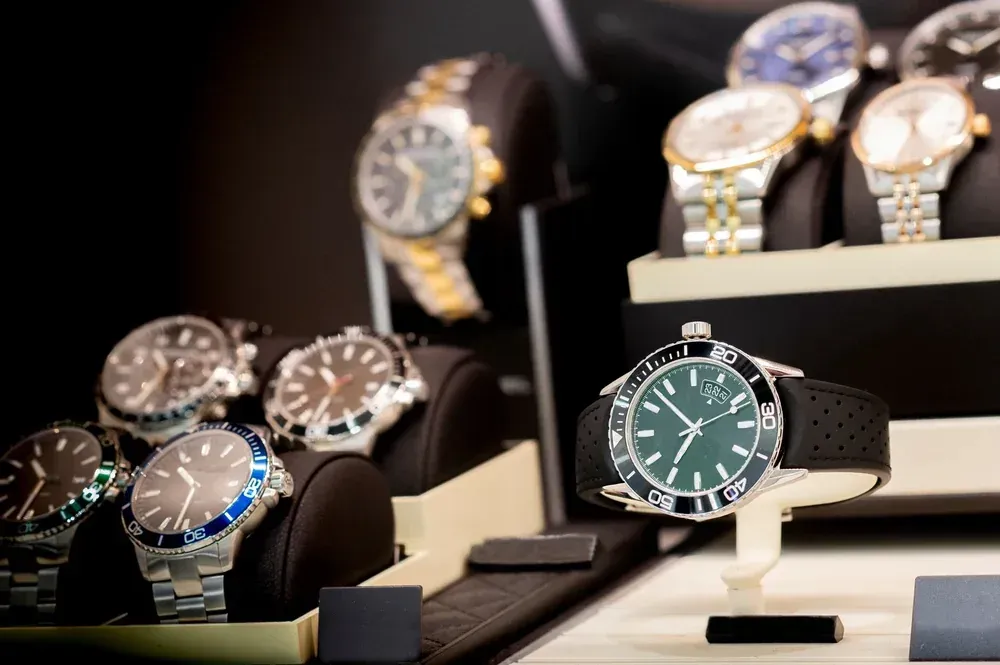 Exhibición de relojes de lujo en pedestales, con diversos colores de correa y esfera.