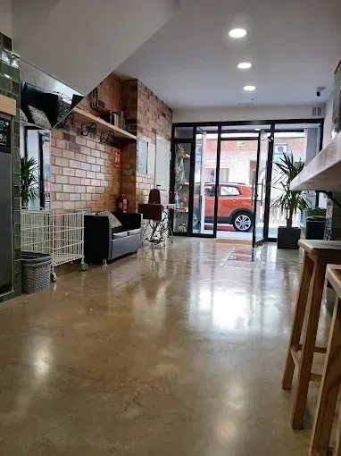 Una gran habitación con muchos muebles y un coche aparcado al fondo.