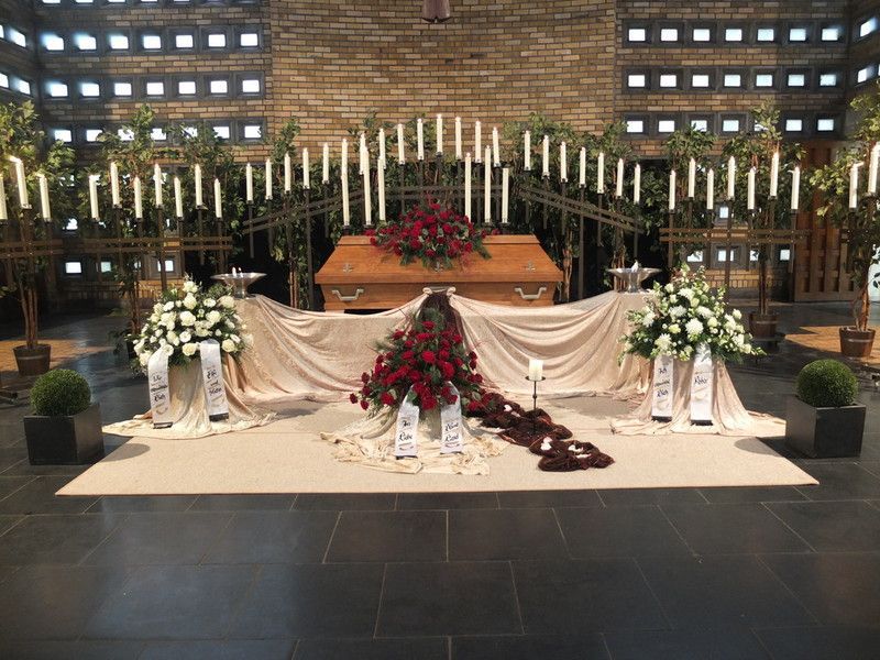 Ein Sarg in einer Kirche mit Blumen und Kerzen