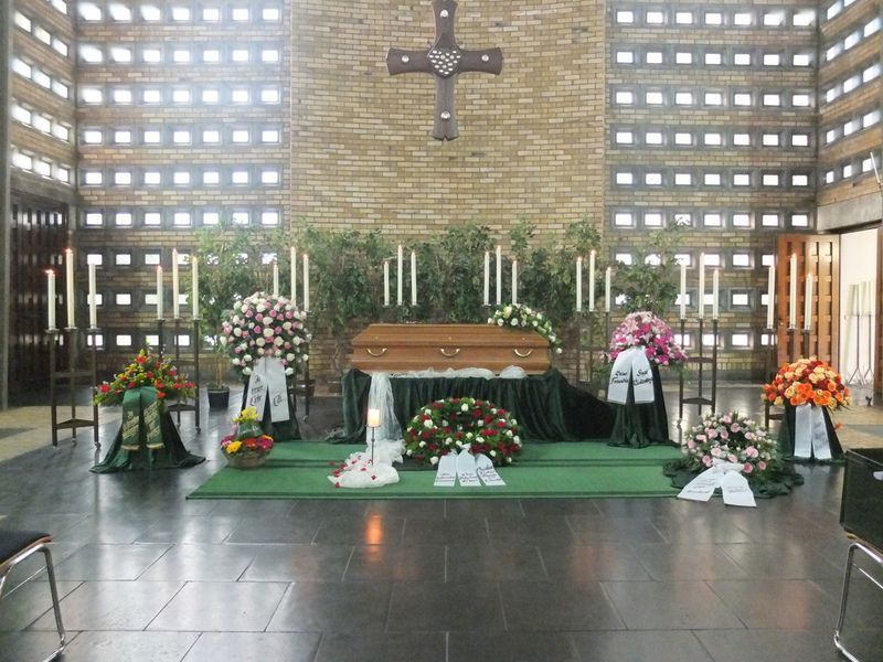Ein Sarg in einer Kirche mit Blumen und Kerzen