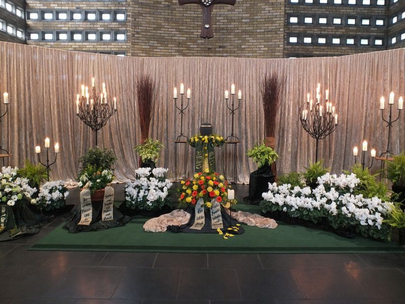 Eine Kirche mit Blumen und Kerzen und einem Kreuz an der Wand