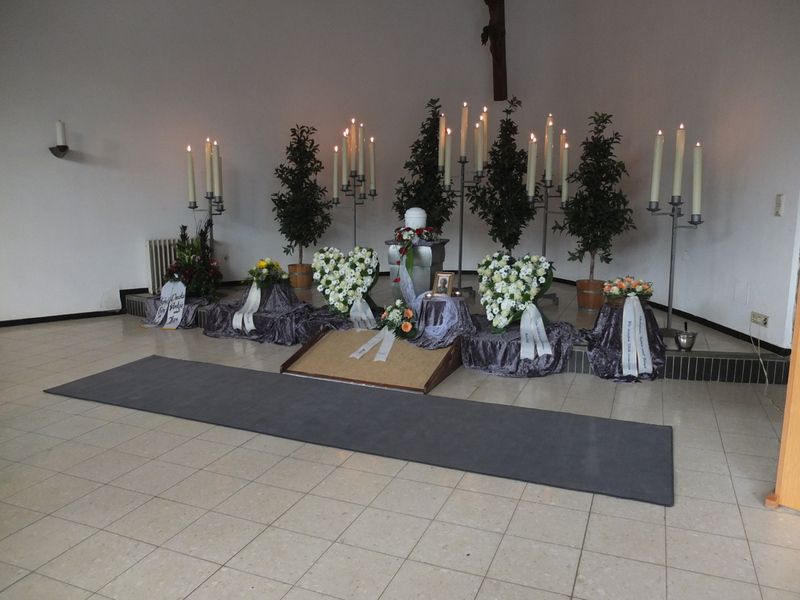 Ein Raum mit Kerzen und Blumen auf dem Boden