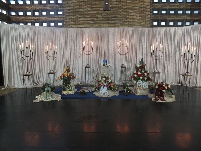 Eine Präsentation von Blumen und Kerzen vor einem weißen Vorhang