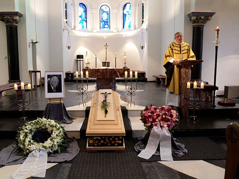 Ein Mann in einem gelben Gewand steht an einem Podium in einer Kirche
