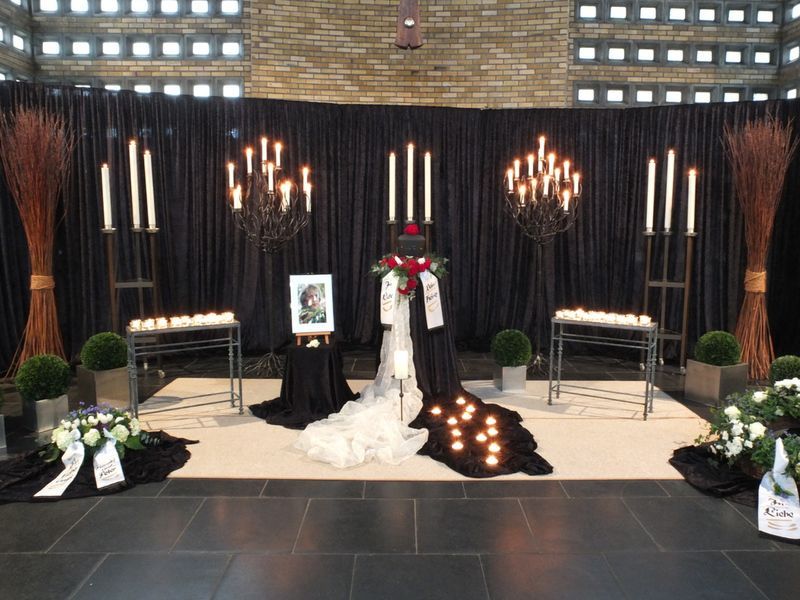 Eine Ausstellung von Kerzen und Blumen in einem Raum