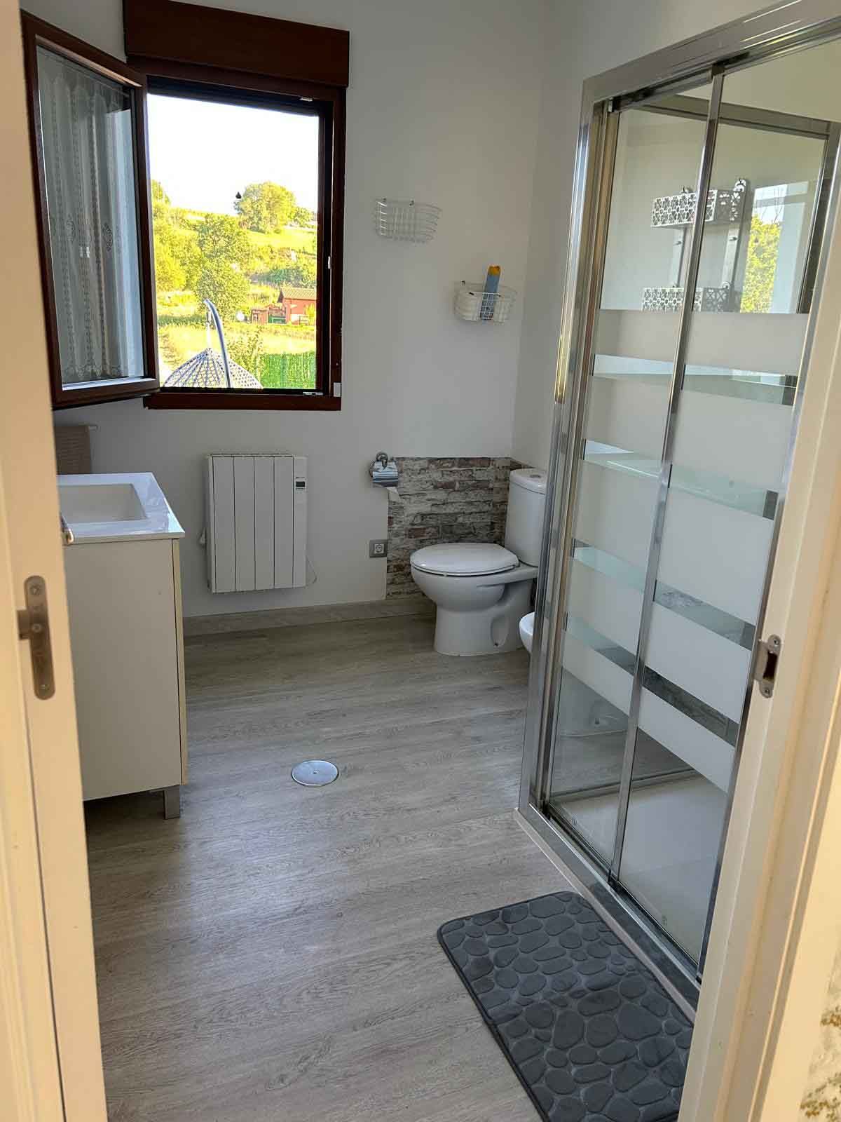 Un baño con inodoro, lavabo y ducha.