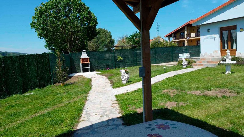 Un camino que conduce a una casa con parrilla en el patio trasero.