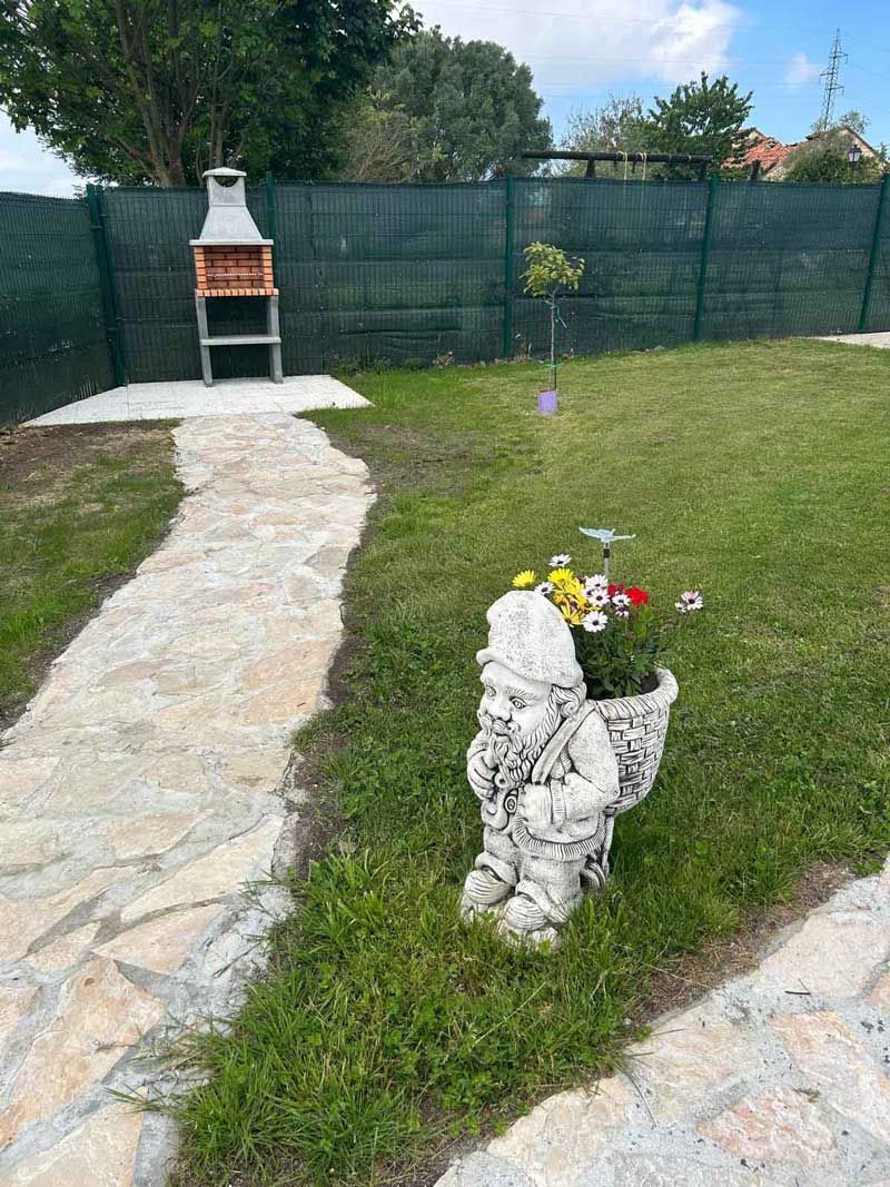 Hay una estatua de un gnomo en el césped del patio trasero.