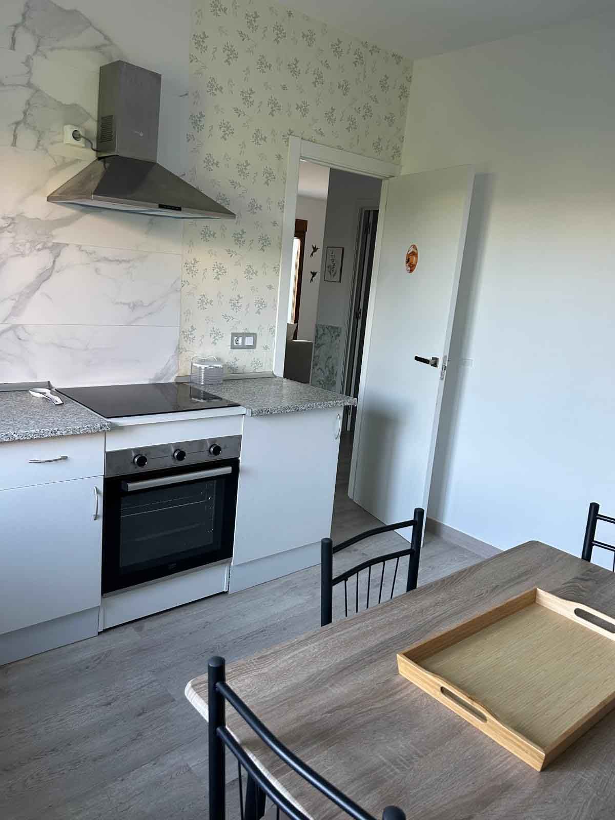 Una cocina con una mesa y sillas y una bandeja sobre la mesa.