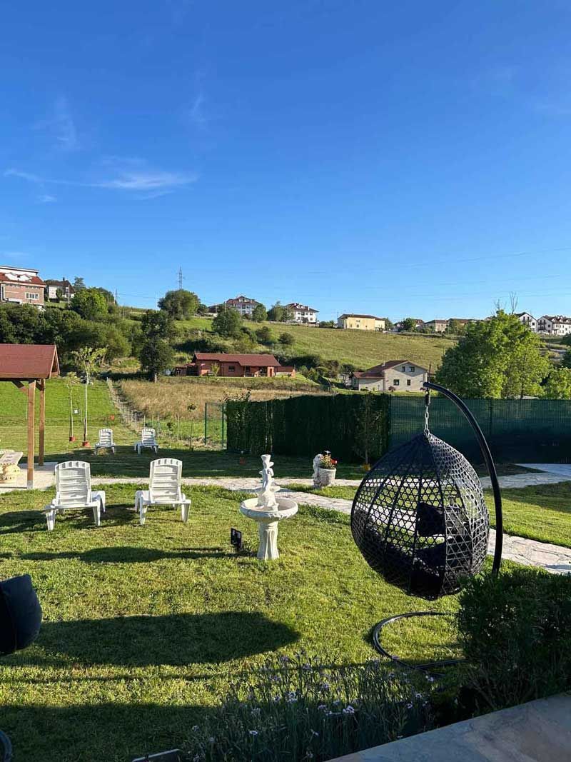 Hay una silla colgante en el medio del jardín.