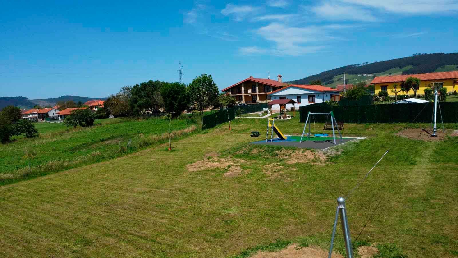 Hay un parque infantil en medio de un campo de hierba.