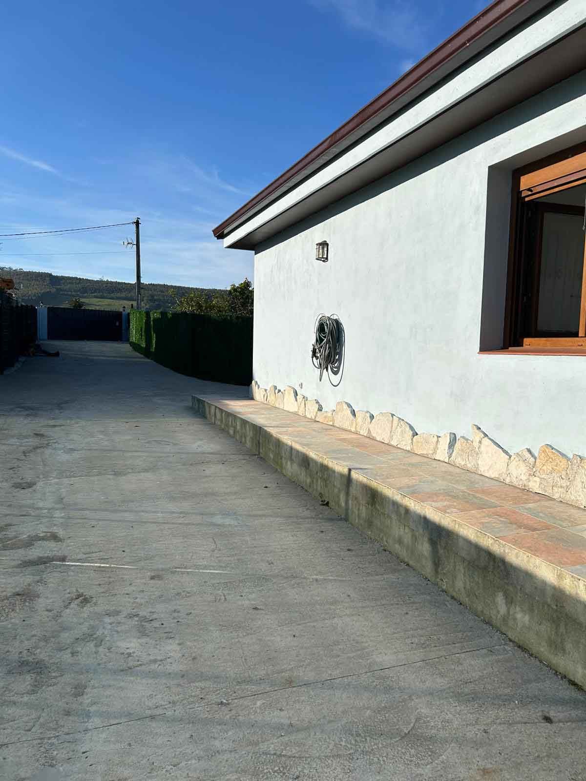 Una casa blanca con una ventana en el costado.
