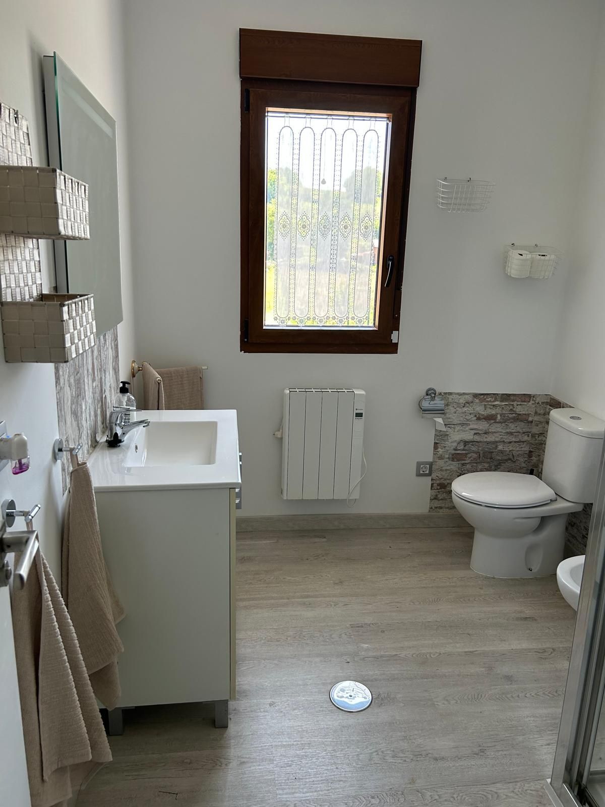 Un baño con lavabo, inodoro y ventana.