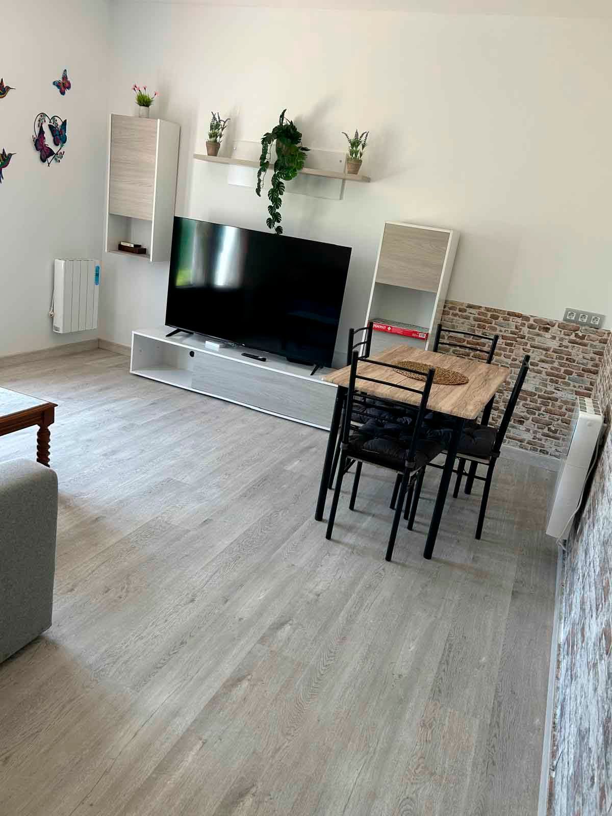 Una sala de estar con una mesa y sillas y un televisor de pantalla plana.