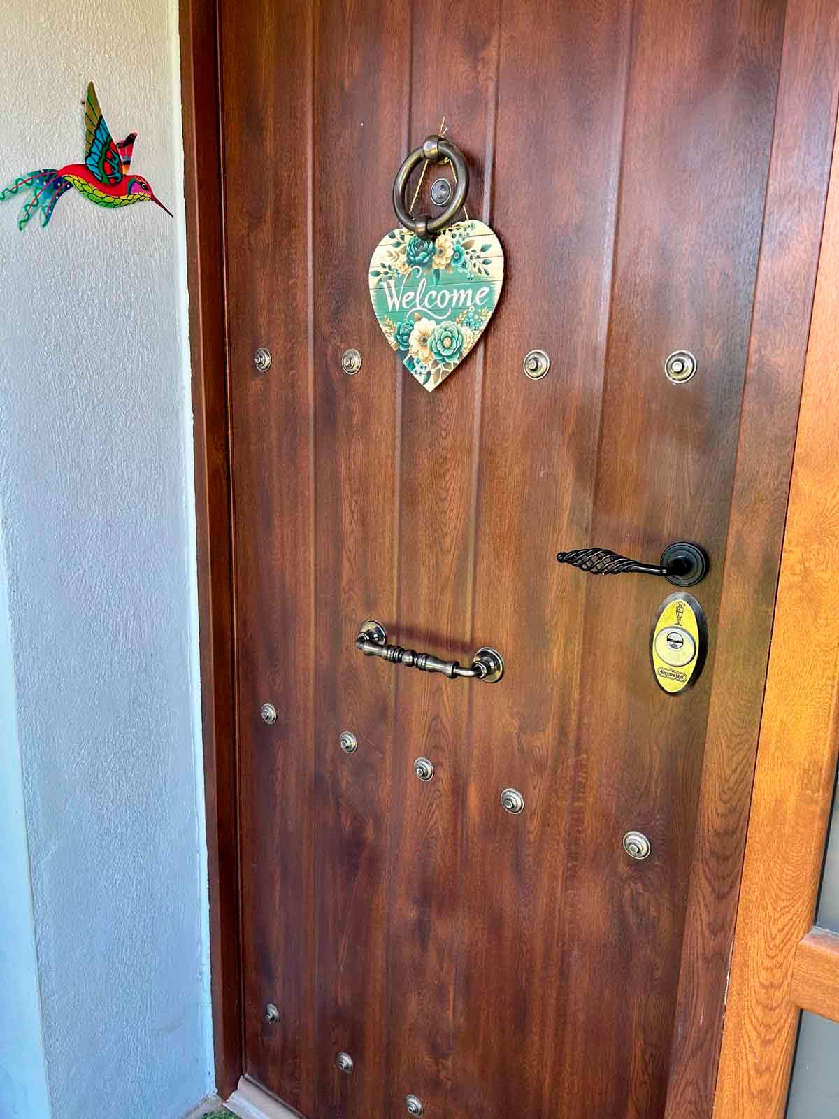 Una puerta de madera con un cartel de bienvenida colgado en ella.