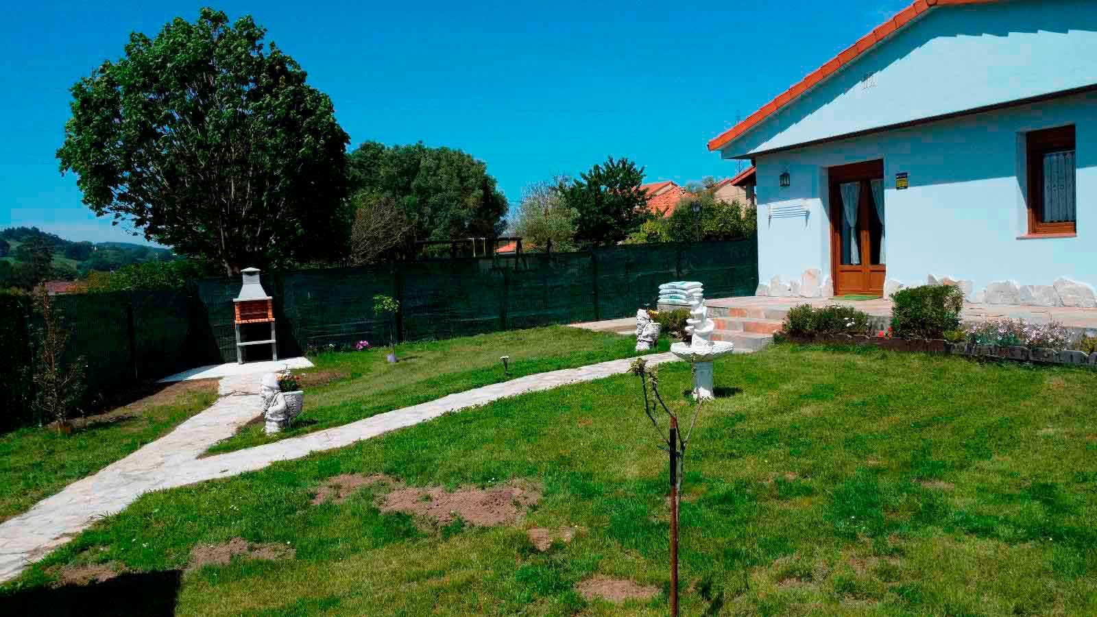 Una casa blanca con un gran césped delante de ella.