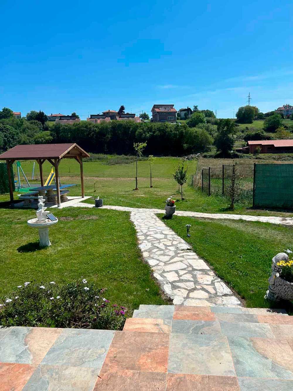 Un camino de piedra que conduce a un mirador en medio de un exuberante campo verde.