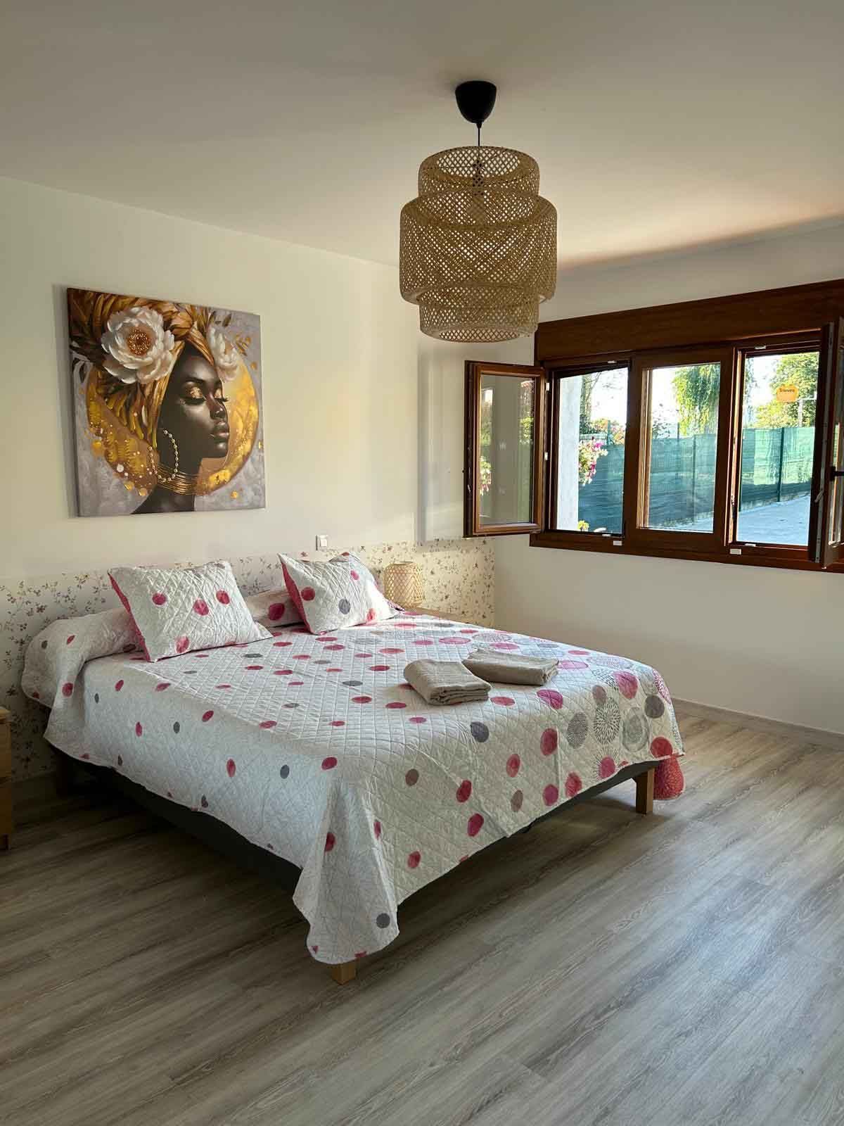 Un dormitorio con una cama grande y un cuadro en la pared.