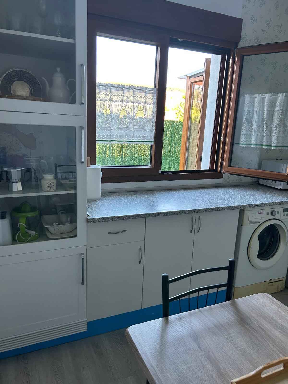 Una cocina con mesa y sillas y una lavadora.