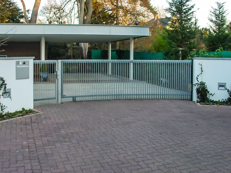 Eine gemauerte Auffahrt, die zu einem Haus mit einem Schiebetor führt