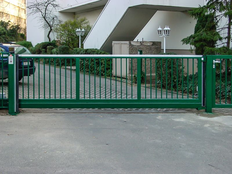 Ein grünes Schiebetor vor einem Gebäude