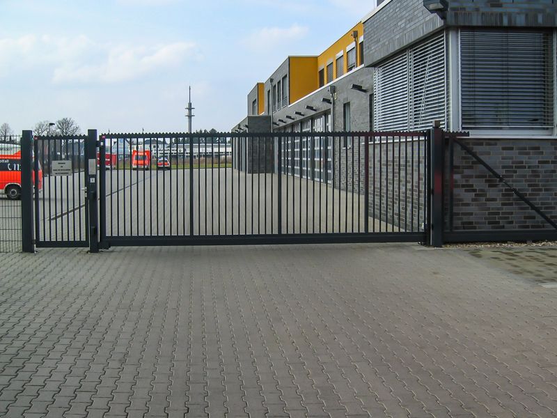 Vor einem Gebäude ist ein Schiebetor geöffnet