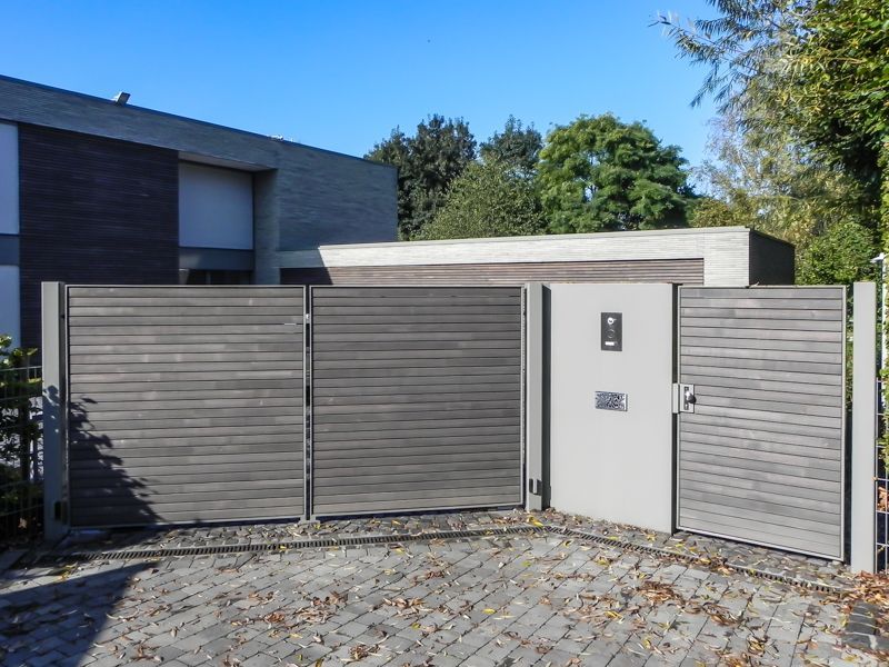 Ein Haus mit einem Zaun und einem Tor davor