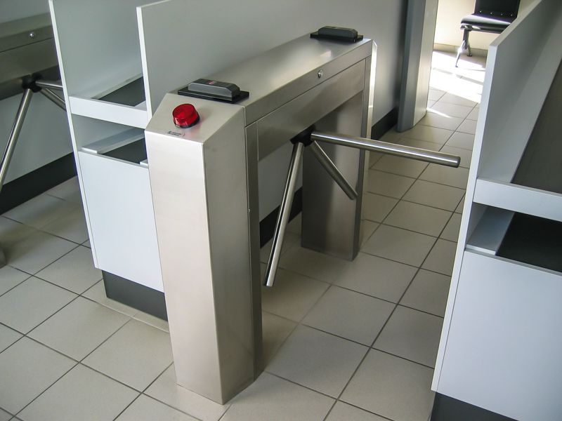 Ein Drehkreuz aus Edelstahl mit einem roten Knopf darauf