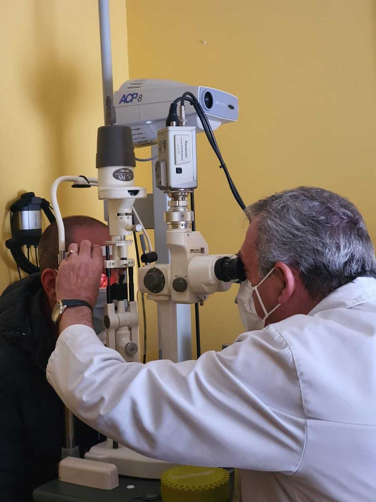 Un oftalmólogo examina a un paciente con una lámpara de hendidura en una clínica.