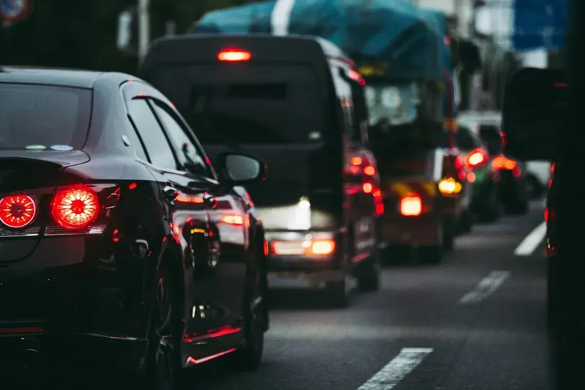 Una fila de coches circula por una calle de la ciudad por la noche.
