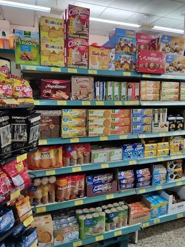 Estantería de tienda de conveniencia repleta de cajas surtidas de cereales y aperitivos en envases llamativos.