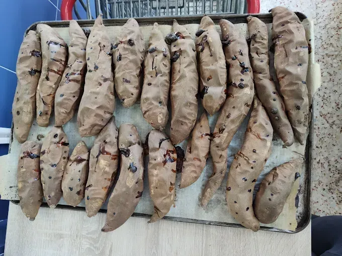 Bandeja de plátanos o bananas pelados y con manchas marrones dispuestos en filas sobre una estera tejida.