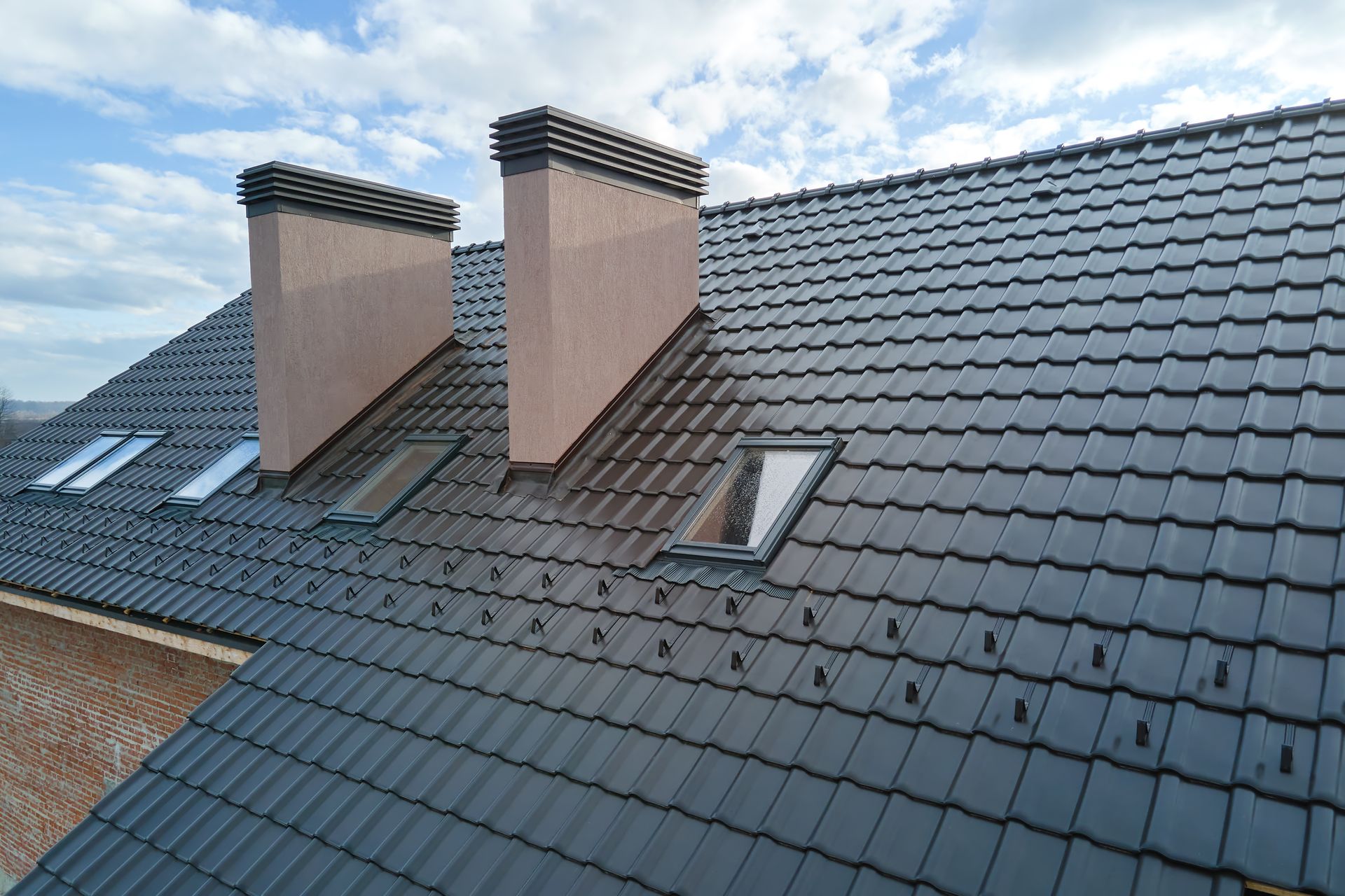 Gros plan des lucarnes et des cheminées en briques sur le toit d'une maison