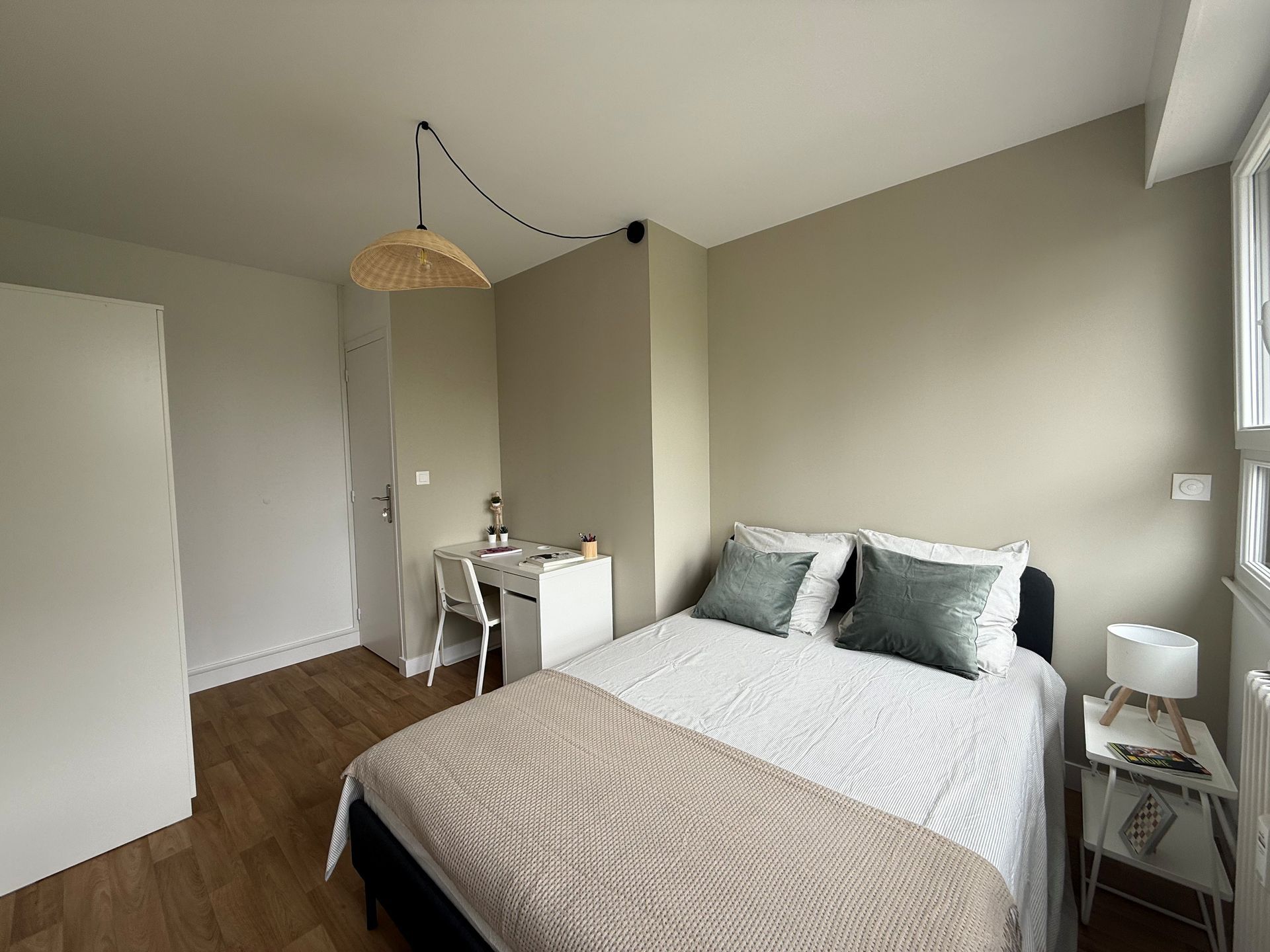 Vue intérieure : porte donnant sur une cuisine équipée de placards, d’électroménagers et d’un sol à motifs. 