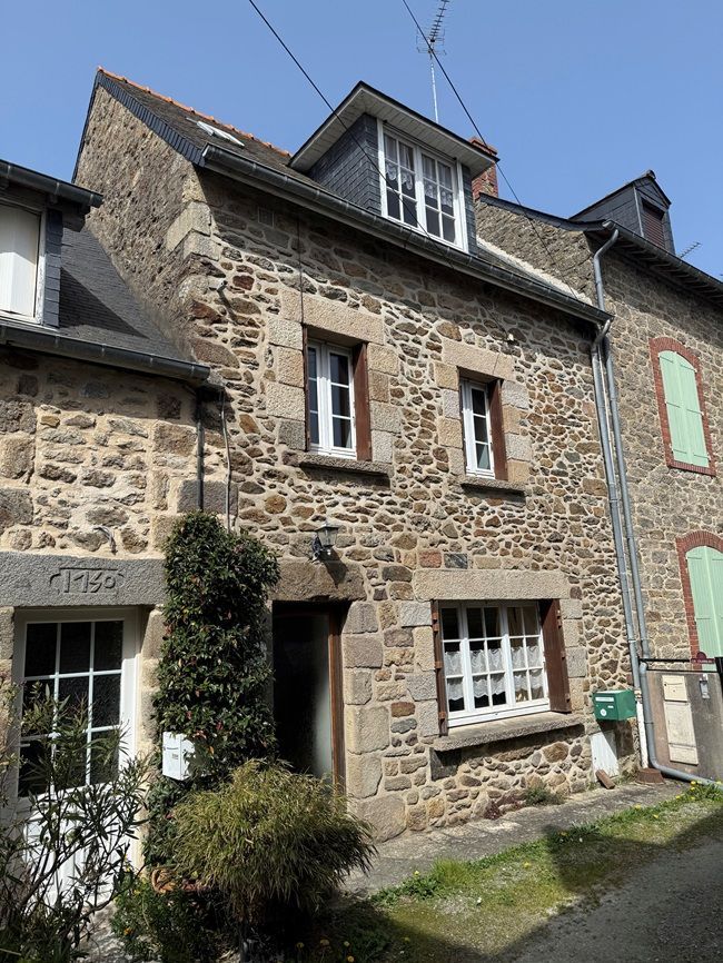 Chambre avec lit, bureau et porte ; linge de lit à motifs noirs et blancs, murs clairs.