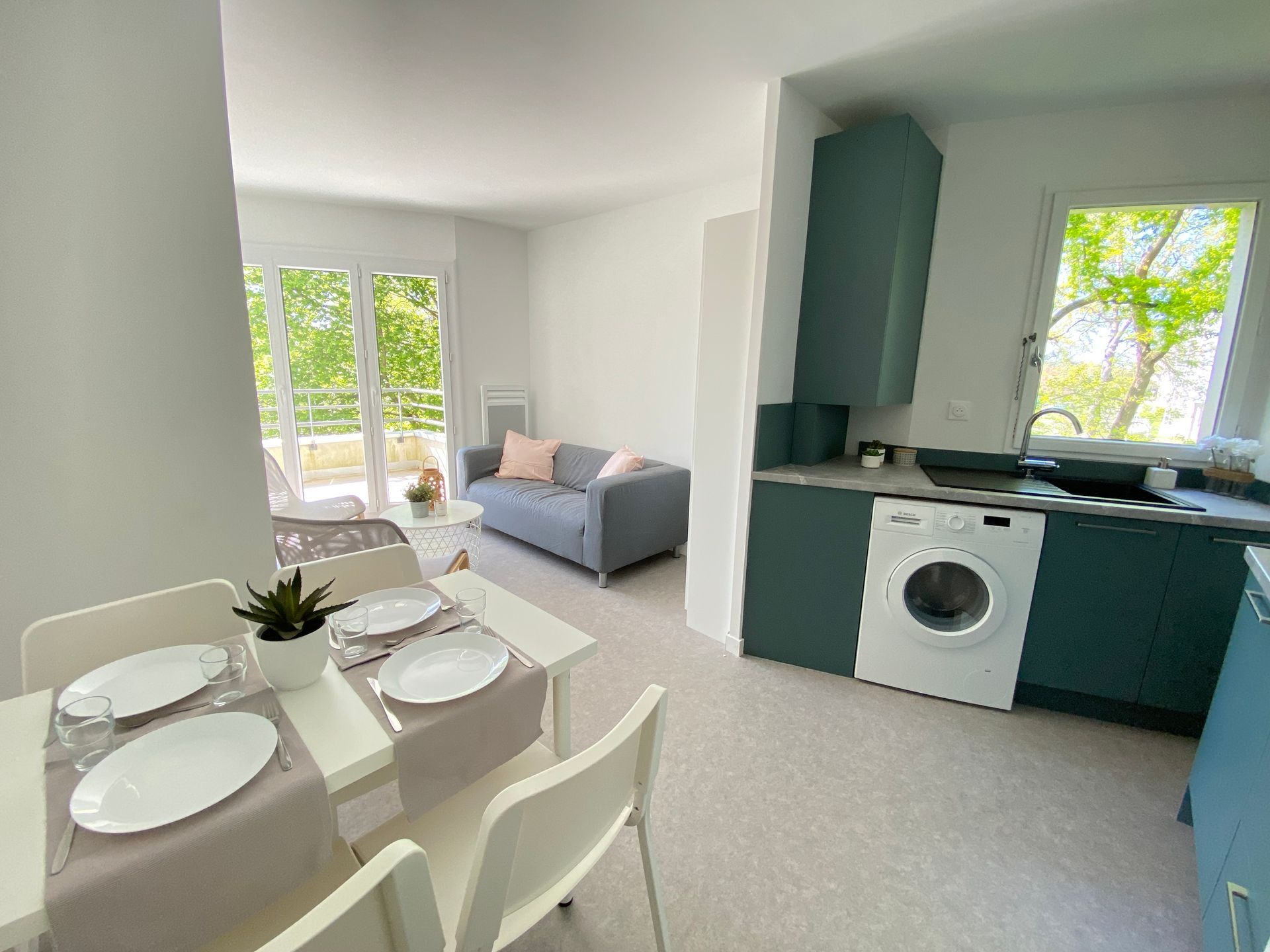 Chambre avec lit, bureau et armoire blanche ; murs de couleur neutre et parquet.