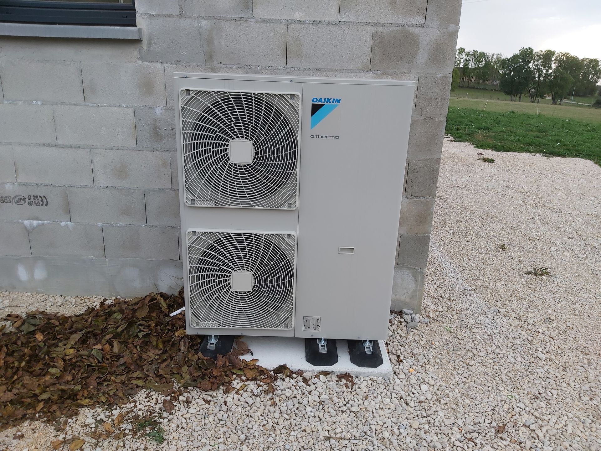 Unité de climatisation extérieure à côté d'une maison.