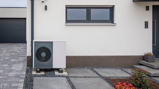 Extérieur de maison moderne avec une petite pompe à chaleur.