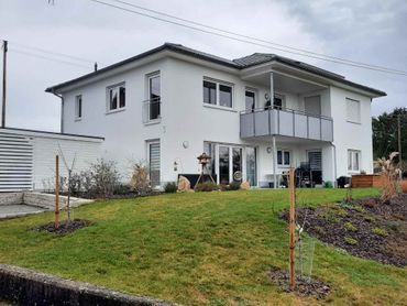 Weißes Einfamilienhaus mit Garten