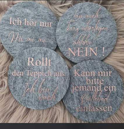 Ein Set mit vier Untersetzern mit deutschen Wörtern darauf.