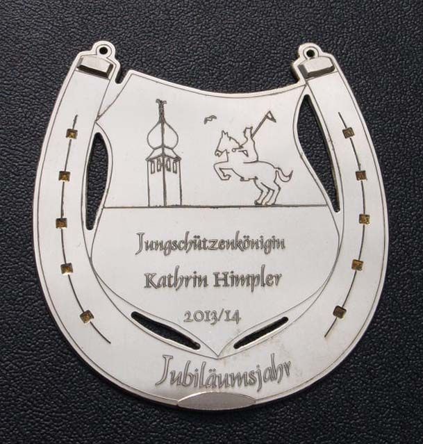 Ein Hufeisen mit dem Bild eines Mannes, der auf einem Pferd reitet