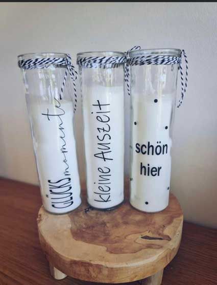 Auf einem Holzhocker stehen drei Kerzen.