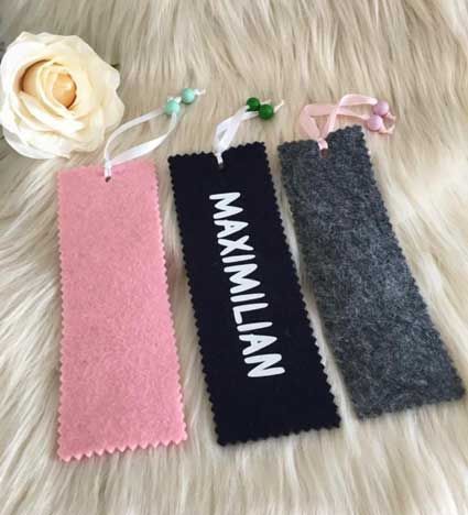 Auf einem pelzigen Untergrund liegen drei Lesezeichen mit dem Namen Maximilian.