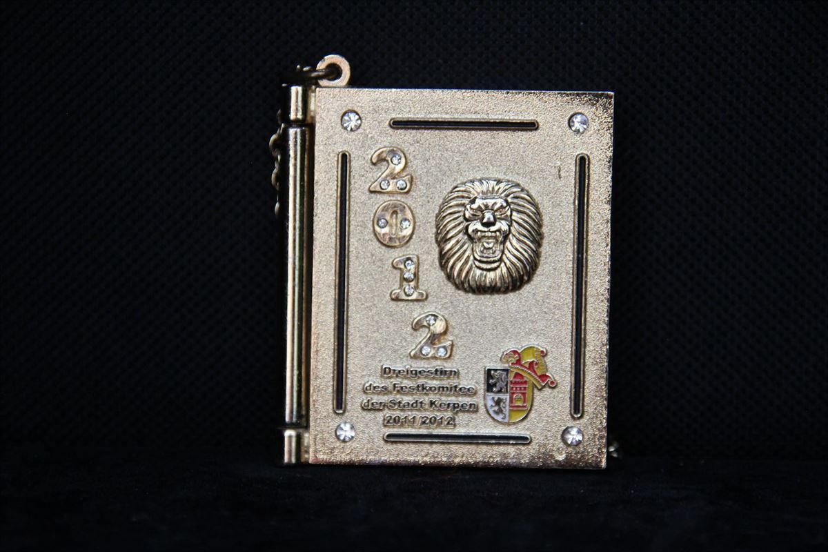 Ein Anhänger in Buchform mit einem Löwen auf dem Einband