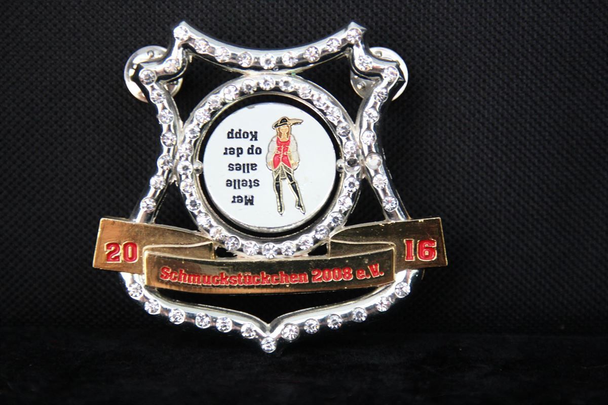 Ein silbernes und goldenes Abzeichen mit der Jahreszahl 2008