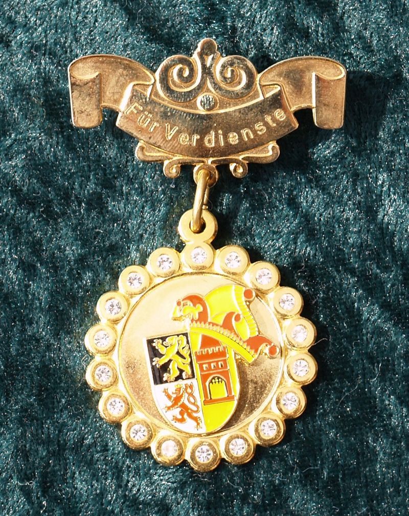 Eine Goldmedaille mit dem Wort „Verdienste“ darauf