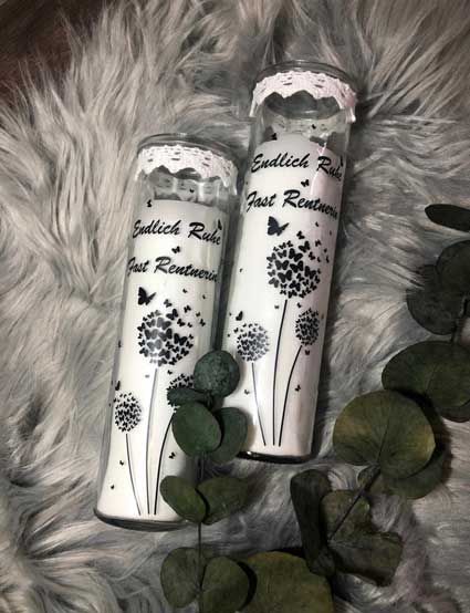 Auf einer Decke stehen zwei Kerzen mit Löwenzahn.