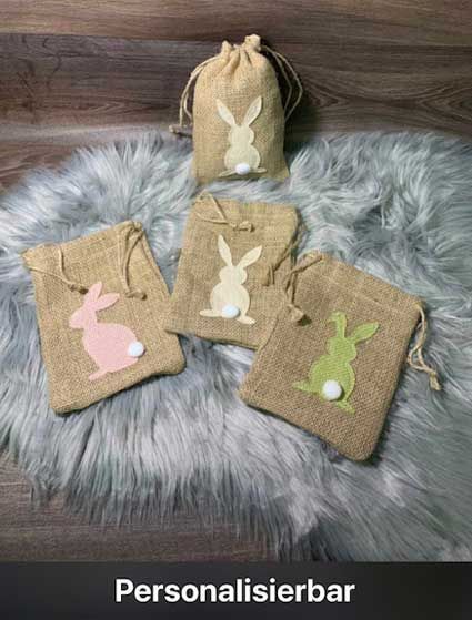 Auf einem Fellteppich liegen vier Säcke mit Kaninchen darauf.