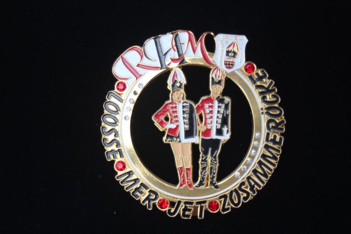 Ein Abzeichen mit einem Mann, der ein Akkordeon spielt, und einer Frau, die ein Akkordeon hält